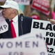 Trump kisses a “Women for Trump” sign during a campaign rally in Florida. Photo via AP